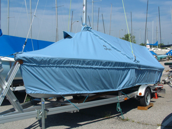 Skirted sailboat cover extending below the rubrail to protect hull sides, transom, and bow